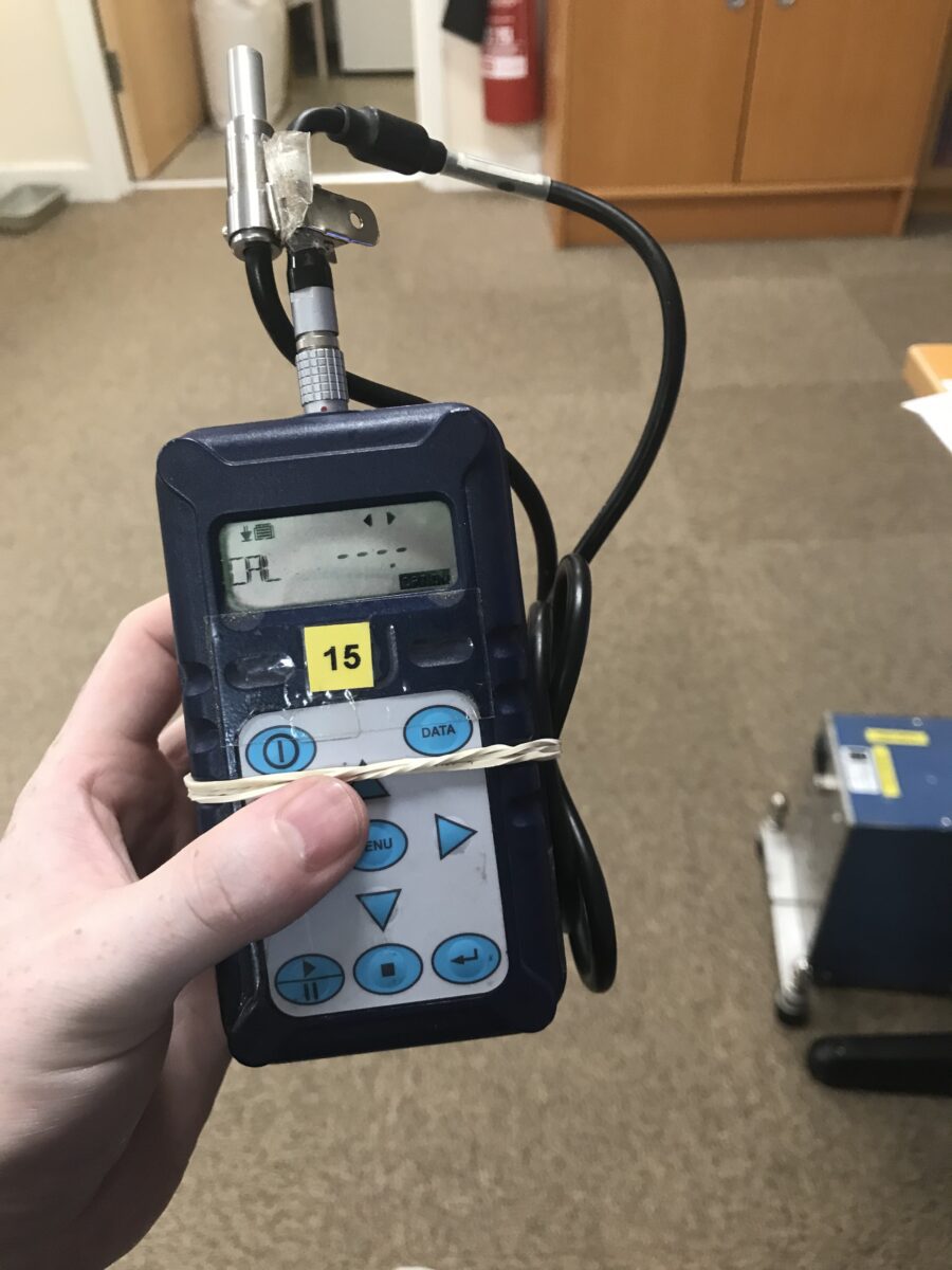 A hand holding a sound level meter