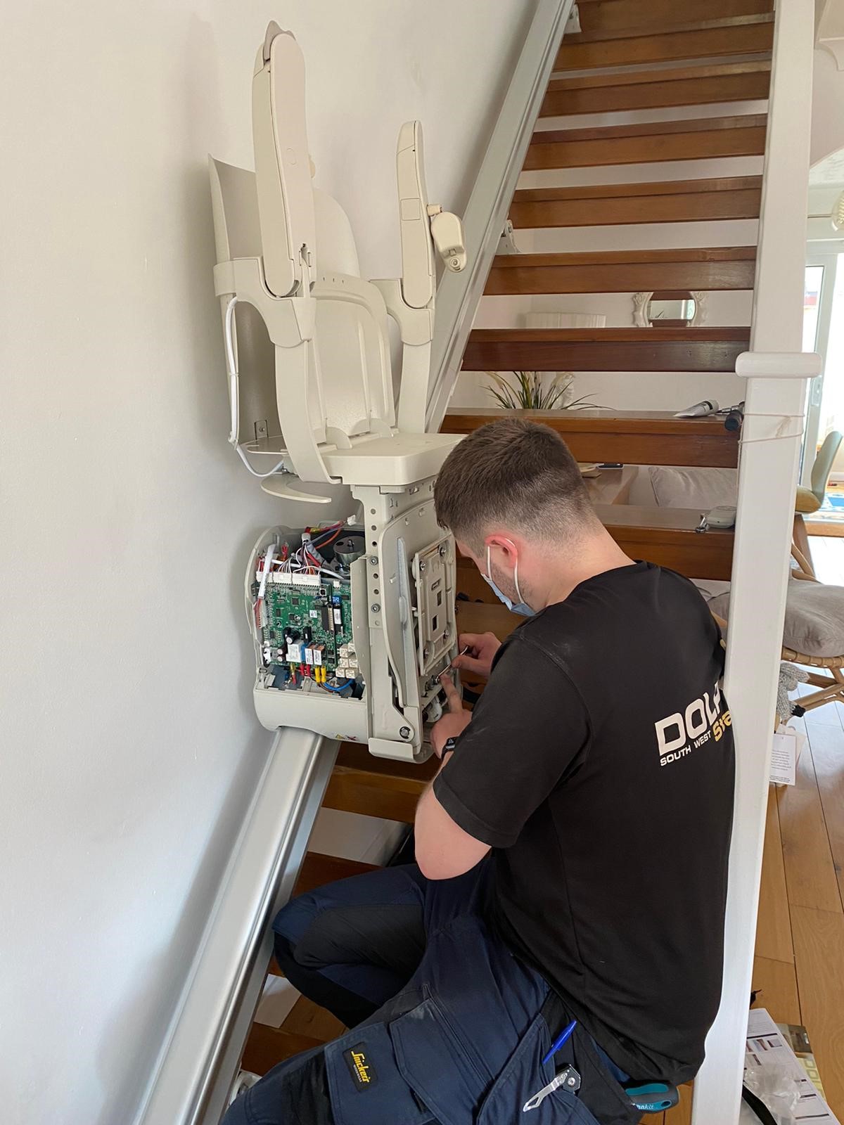 Ben fixing stairlift at the bottom of the stairs