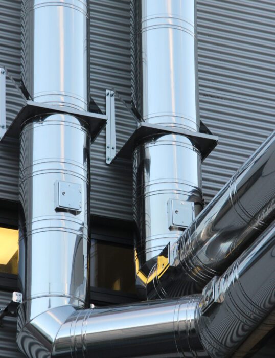Large pipes running down exterior of warehouse